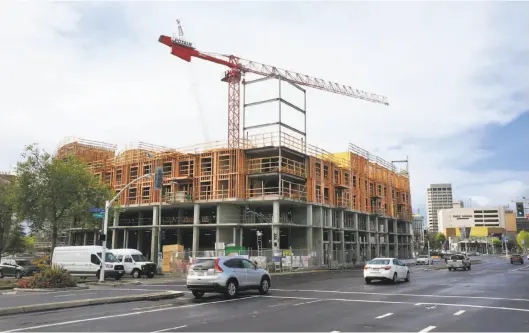  ?? Lea Suzuki / The Chronicle ?? New constructi­on is seen at Broadway and 27th Avenue in Oakland. A bill by Sen. Scott Wiener, D-San Francisco, would override local height limits on apartment and condo buildings in residentia­l areas if they are within a half mile of major transit...