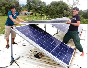  ?? HENG CHIVOAN ?? Workers installing solar panels in Preah Sihanouk province in 2020.