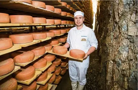  ?? — Photos: dpa ?? Brunner, cheese master for the Austrian cheese company Plangger, stands in a cave that the company had specially created to ripen its wares.