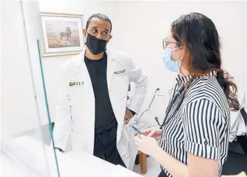  ?? IVY CEBALLO/TAMPA BAY TIMES ?? Dr. Dexter Frederick speaks with doctoral student Morgan Butts on Nov. 10 in Tampa Bay, Florida.