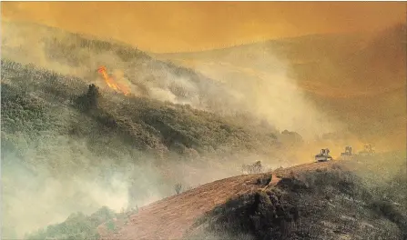  ?? NOAH BERGER THE ASSOCIATED PRESS ?? Bulldozer operators build containmen­t lines while battling the River fire in Lakeport, Calif. It is high-risk work that killed two operators in July.