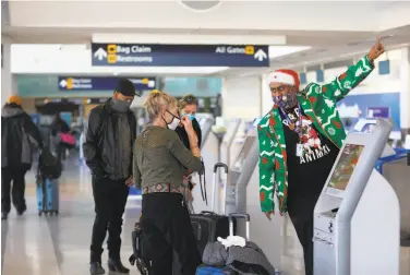  ?? Yalonda M. James / The Chronicle ?? Gail G. ( left) is aided by a Southwest Airlines employee as she checks in at the Oakland Internatio­nal Airport, where Terminal 1 was desolate at 9 a. m. and Terminal 2 lacked the typical holiday season crowds.