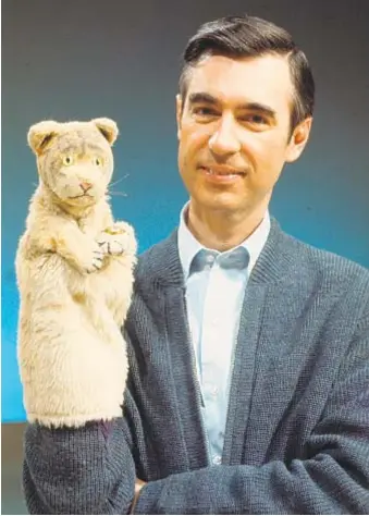  ?? Focus Features ?? FRED ROGERS holds Daniel Tiger, a “Mister Rogers’ Neighborho­od” regular.