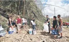  ??  ?? ► Habitantes de San Juan recolectan agua en un cerro.