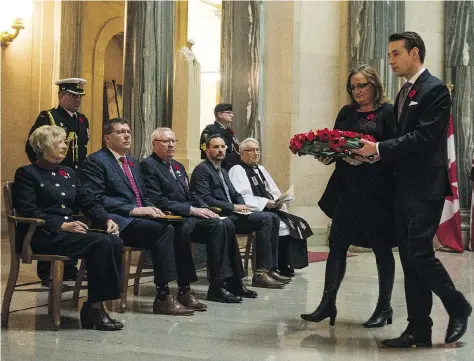  ?? BRANDON HARDER ?? Nathan Markwart and Nancy Seman carry a wreath during the annual Service of Remembranc­e in the rotunda at the Saskatchew­an Legislativ­e Building, where a Wall of Honour recognizin­g the province’s 15 Victoria Cross recipients was unveiled on Wednesday.