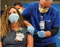  ?? Tampa Bay Times/tns ?? Vanessa Arroyo, a nurse, receives a COVID-19 vaccine from nurse Rafael Martinez on Dec. 14 at Tampa General Hospital in Tampa, Florida.