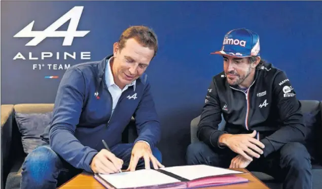  ??  ?? Laurent Rossi, CEO de Alpine, firma el contrato que confirma la segunda temporada de Fernando Alonso con el equipo francés, bajo la atenta mirada del piloto asturiano.