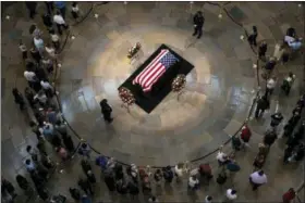  ?? J. SCOTT APPLEWHITE — THE ASSOCIATED PRESS ?? Members of the public walk past the flag-draped casket bearing the remains of John McCain of Arizona, who lived and worked in Congress over four decades, in the U.S. Capitol rotunda in Washington, Friday. McCain was a six-term senator from Arizona, a former Republican nominee for president, and a Navy pilot who served in Vietnam where he endured five-and-a-half years as a prisoner of war. He died Aug. 25 from brain cancer at age 81.