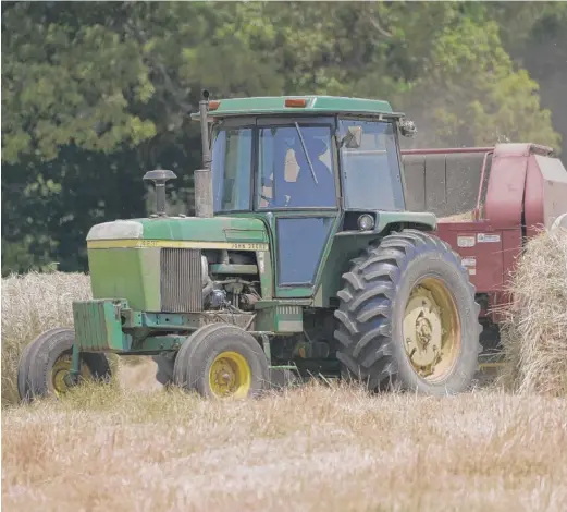  ??  ?? John Wesley Boyd Jr. runs his hay baler in Boydton, Virginia. “I’m owning land that many of my forefather­s worked when it was scotch-free. You know — slave labor, man,” he says. “I’m just trying to make them proud.”