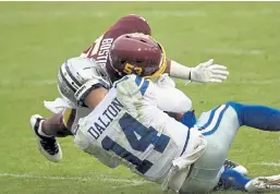  ?? Patrick McDermott, Getty Images ?? Dallas quarterbac­k Andy Dalton is hit and injured by Washington’s Jon Bostic in the third quarter Sunday in Landover, Md.