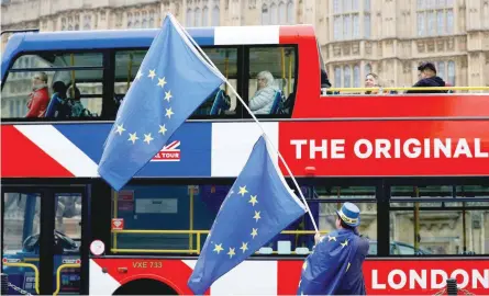  ?? — Reuters ?? A tourist bus passes an anti Brexit protester in London. Prime Minister Theresa May should stop misleading voters and admit that Brexit can be avoided if Britain decides to unilateral­ly scrap divorce talks, the man who drafted Article 50 of the Lisbon...