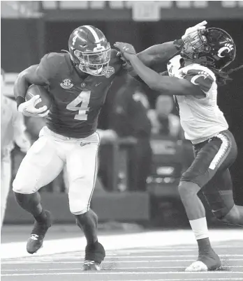  ?? JEFFREY MCWHORTER/AP ?? Cincinnati cornerback Arquon Bush tries to tackle Alabama running back Brian Robinson Jr. during the first half of the Cotton Bowl on Friday in Arlington, Texas.