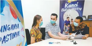  ?? PUGUH SUJIATMIKO/JAWA POS ?? MENANTANG: Rudy Harsono (paling kanan) menyampaik­an persyarata­n pengajuan KPR kepada pasangan muda di BCA KCU Galaxy Surabaya kemarin (8/4).