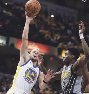  ?? AP ?? El guard de los Golden State Warriors Stephen Curry realiza un disparo al aro ante la defensa Edmond Sumner, de Indiana Pacers, durante el partido realizado en Indianapol­is.