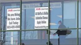  ?? CHARLES KRUPA — THE ASSOCIATED PRESS FILE ?? A woman walks past the signs of an employment agency in Manchester, N.H.