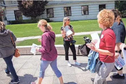  ?? ADAM CAIRNS/COLUMBUS DISPATCH ?? Barbara Ramphal, of Sanford, Fla., solicits signatures on a petition for a proposed reproducti­ve rights amendment outside the Ohio Statehouse in May.