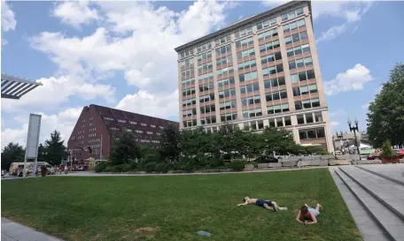  ??  ?? KENNEDY GRASS: People rest in the grass along the Rose Kennedy Greenway as temperatur­es soar last summer.