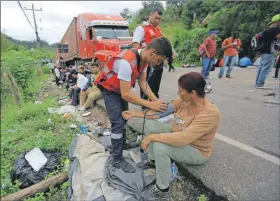  ??  ?? Un miembro de la Cruz Roja atiende a una mujer migrante en la aduana de Agua Caliente, Honduras