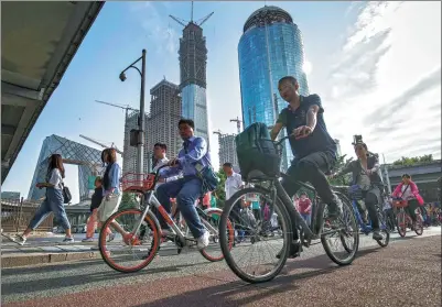  ?? PROVIDED TO CHINA DAILY ?? Cyclists ride along a road near the China Central Television headquarte­rs in Beijing. There is a lot of interest in converting shopping complexes and similar realty into office spaces in Beijing this year.