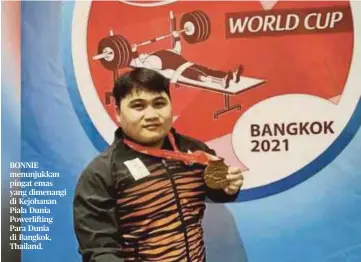  ??  ?? BONNIE menunjukka­n pingat emas yang dimenangi di Kejohanan Piala Dunia Powerlifti­ng Para Dunia di Bangkok, Thailand.