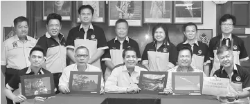  ??  ?? Dennis (seated centre) with other committee and Miri Photograph­ic Society members holding last year’s winning photos.