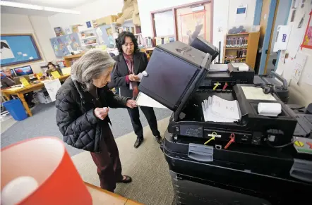  ?? LUIS SÁNCHEZ SATURNO/THE NEW MEXICAN ?? Jacqueline Dunnington, 88, of Santa Fe, gets help Tuesday depositing her ballot from elections judge Margaret Merdler at Acequia Madre Elementary School.