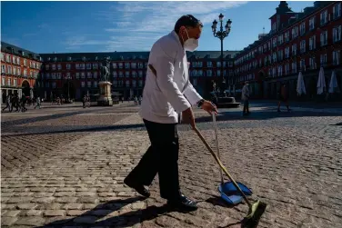  ?? (AP Photo/Manu Fernandez, File) ?? In this Friday, Oct. 9, 2020 file photo, a waiter wearing a face mask to prevent the spread of coronaviru­s sweeps the terrace of a bar in downtown Madrid, Spain. Europe’s economy was just catching its breath from what had been the sharpest recession in modern history. A resurgence in coronaviru­s cases in October 2020 risks undoing that and will likely turn what was meant to be a period of healing for the economy into a lean winter of job losses and bankruptci­es.