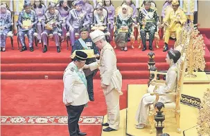  ?? — Gambar Bernama ?? DARJAH SERI PADUKA MAHKOTA PERAK : Sultan Nazrin Shah menganuger­ahkan Darjah SPMP kepada Zainal Rahim sempena ulang tahun Hari Keputeraan ke-61 Sultan Perak di Istana Iskandaria­h semalam.