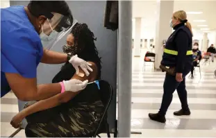  ?? Tribune News Service/los Angeles Times ?? A’ja Thrasher, 37, of Los Angeles, gets a one-dose COVID-19 vaccine by Johnson & Johnson from nurse Leshay Brown, left, at the Baldwin Hills Crenshaw Plaza in Los Angeles on March 11..