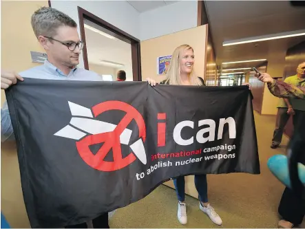  ?? FABRICE COFFRINI / AFP / GETTY IMAGES ?? Nuclear disarmamen­t group ICAN executive director Beatrice Fihn, right, and co- ordinator Daniel Hogstan hold the group’s banner after it won the Nobel Peace Prize on Oct. 6 for its decade-long campaign to rid the world of the atomic bomb — an issue...