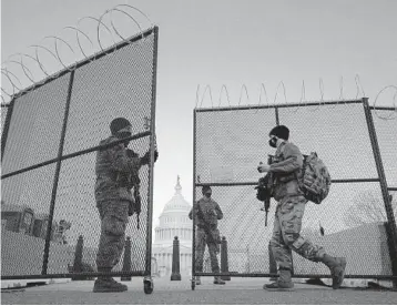  ?? CAROLYN KASTER/AP ?? National Guard soldiers open a gate of the perimeter fence around the U.S. Capitol this month in Washington. Security fencing is set to be removed from the Capitol, but metal detectors remain stationed outside the House chamber.