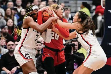  ?? Jessica Hill/Associated Press ?? UConn’s Aaliyah Edwards, left, and Caroline Ducharme, right, pressure St. John’s Rayven Peeples, center, on Tuesday in Hartford.