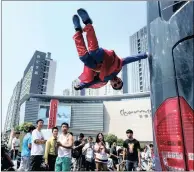  ?? PICTURE: REUTERS ?? A performer floats in mid-air as he holds on to a moving bus during the Internatio­nal Magic Festival in Luoyang, Henan province, China, at the weekend.