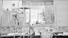  ??  ?? Workers priming the surface of a new truck before it is painted and decorated at Soonchai Industry, a truck assembly factory in the central Thai province of Nakhon Pathom.