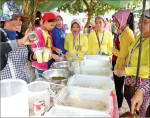  ?? AFP ?? Cambodian women workers buy meals outside a factory in Phnom Penh. The Kingdom’s travel goods exports to the US are on track to reach $500 million this year.