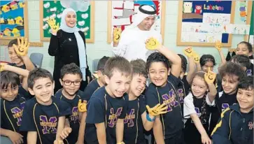  ?? United Arab Emirates Ministry of Happiness ?? UNITED ARAB Emirates Happiness Minister Ohood bint Khalfan Roumi, back left, introduced a “100 days of positivity” campaign, in which students, teachers and administra­tors pledge to practice positive behavior.