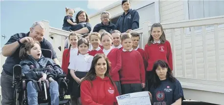  ??  ?? Redby Academy youngsters hand over cash for charity Out of Sight.