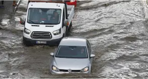  ?? (Osman Orsal/Reuters) ?? VEHICLES DRIVE on a flooded road after heavy rainfall in Istanbul yesterday.