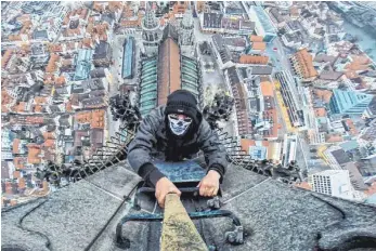  ?? ARCHIVFOTO: KLEIBAUER ?? Völlig verrückt: Ein „Roofer“hängt am Ulmer Münster. Immer wieder klettern junge Menschen außen an dem Turm hoch. Nun wurden zwei von der Polizei geschnappt.