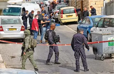  ?? (AFP) ?? Israeli security forces and emergency service personnel gather at a cordoned-off area in Jerusalem's Arab neighbourh­ood of Silwan on Saturday