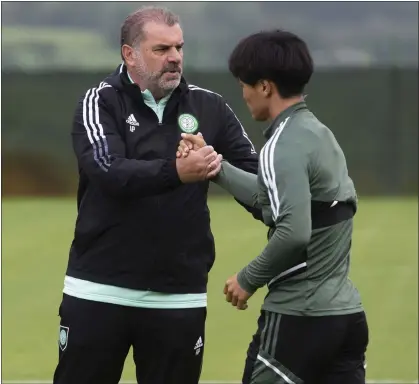  ?? ?? Celtic manager Ange Postecoglo­u greets Reo Hatate as the Japanese returns for preseason
