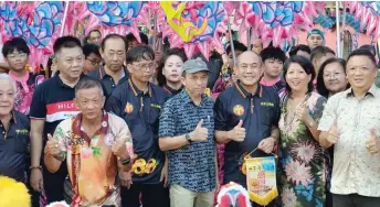  ?? Photo — Ukas ?? Rentap (front, third right), flanked by Rosemarie and Dr Richard, joining other guests in a group photo with the participan­ts of the parade, held in connection with the 100th anniversar­y celebratio­n of the Siang Ti Temple.