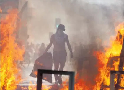  ?? Photo / AP ?? Protesters blocked traffic and lit fires in Santiago yesterday.