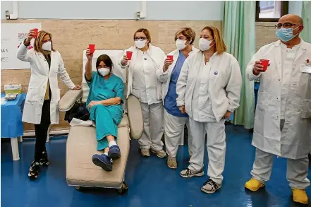  ?? AP ?? Medical staff toast the new year at the vaccine centre of Santo Spirito Hospital in Rome. Over 32,000 doses of Covid19 vaccine have been given to Italian doctors and nurses so far as a nationwide vaccinatio­n campaign continues.