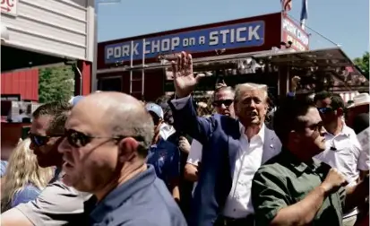  ?? CHARLIE NEIBERGALL/ASSOCIATED PRESS ?? Donald Trump waved to supporters at the Iowa Pork Producers tent during a visit to the Iowa State Fair on Saturday. Attending the event is a rite of passage for presidenti­al aspirants.