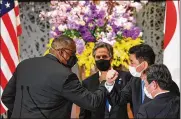  ?? KAZUHIRO NOGI / POOL ?? U.S. Defense Secretary Lloyd Austin (left) elbow bumps with Japanese Defense Minister Nobuo Kishi as U.S. Secretary of State Antony Blinken (center) and Japan’s Foreign Minister Toshimitsu Motegi watch Tuesday.