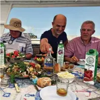  ??  ?? Vladimir Kostenko, agent du port privé (au centre), célèbre l’anniversai­re du doyen des pilotes. Une soupe de poisson et quelques jus…