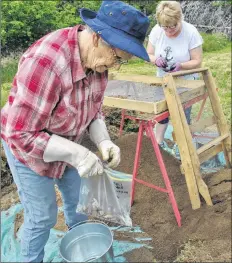  ??  ?? Marie d’Entremont, Pubnico, bags some of her finds at the Fort Saint Louis archeology dig in Port La Tour. In the background is Eunice Rennehan of Barrington Passage. The two were among the 60-plus local residents who signed up to take part in the public archeology program that started the month-long exploratio­n.