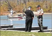  ?? NICK GRAHAM / STAFF ?? Investigat­ors discuss Tuesday’s fatality at Hueston Woods State Park. There were 18 boating deaths in Ohio in 2018.