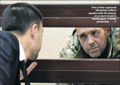  ?? — AP ?? One of the captured Ukrainian sailors speaks with his lawyer in a court room in Simferopol, Crimea, yesterday.